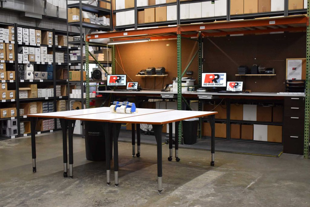 An expansive warehouse featuring numerous shelves and tables used for 3PL services.